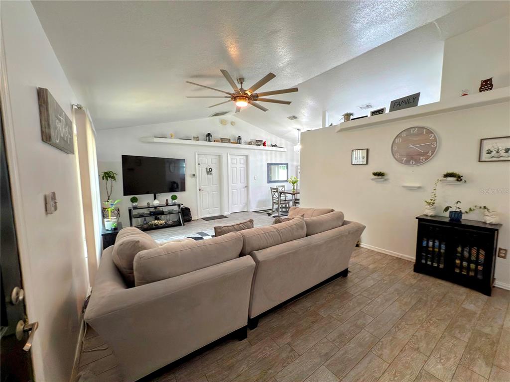 408 Raymond Street Minneola, FL 34715 - Photo 6 of 40 a living room with furniture and a flat screen tv