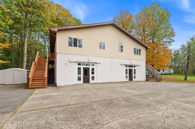 a view of a house with backyard and trees