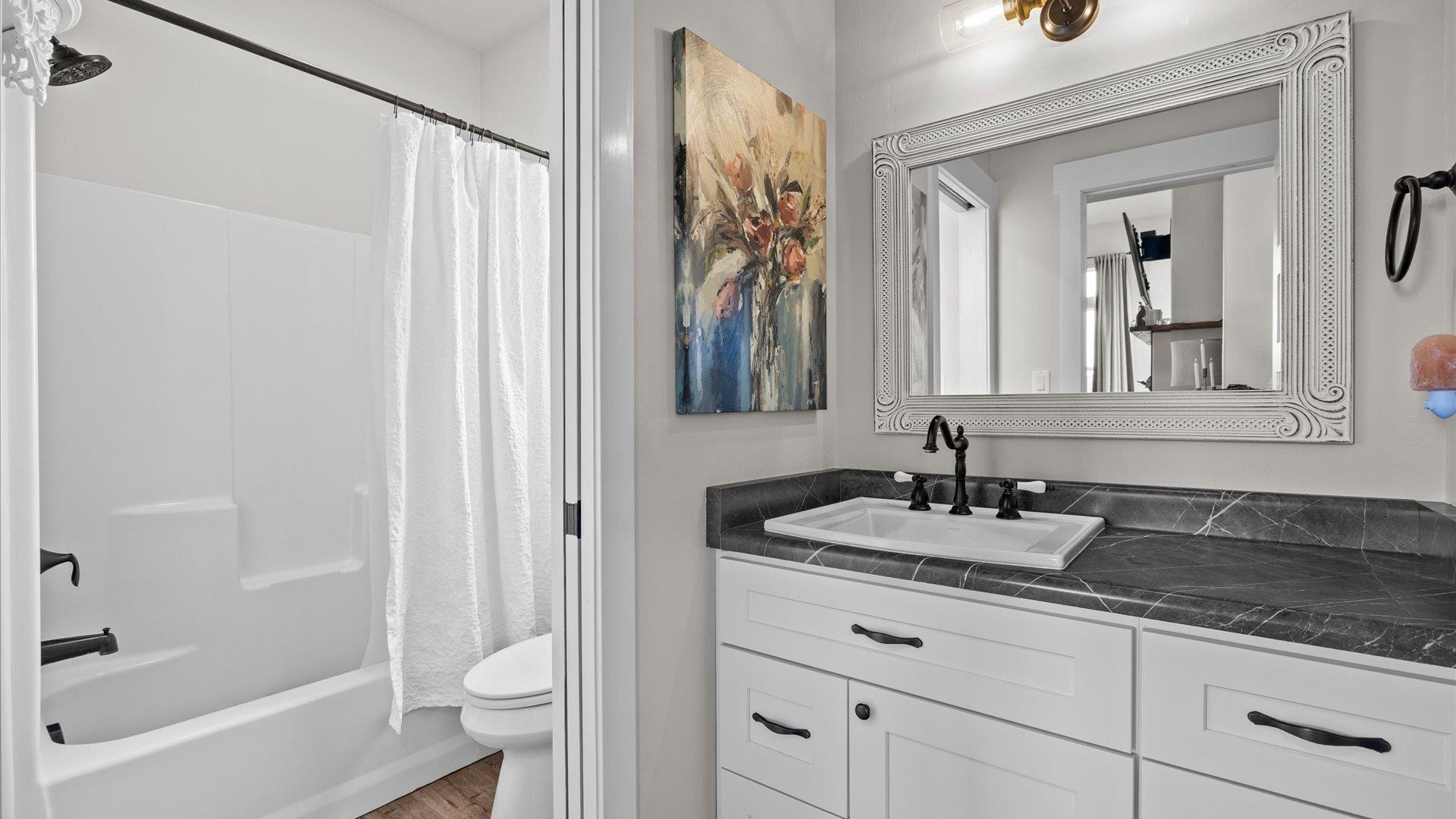 1730 Stremel Creek Fruita, CO 81521 - Photo 24 of 42 a bathroom with a granite countertop sink a mirror a vanity and a bathtub