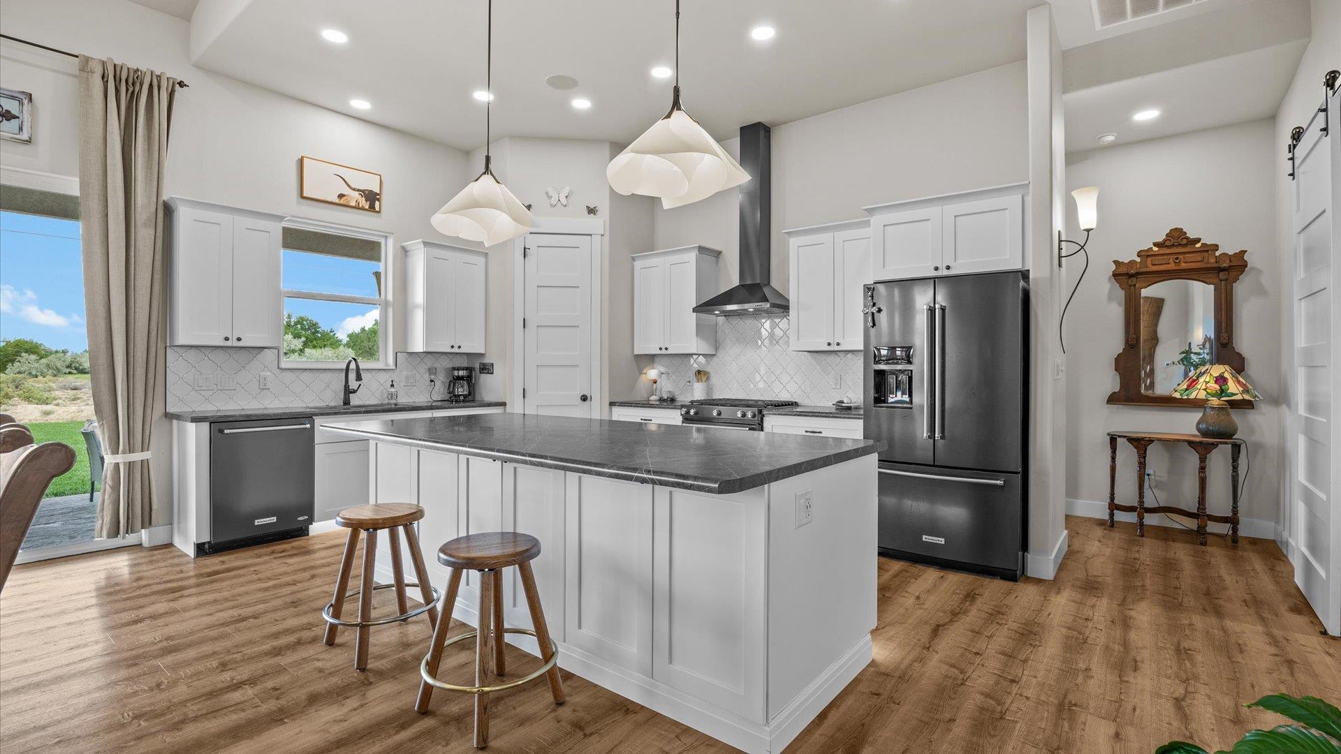 1730 Stremel Creek Fruita, CO 81521 - Photo 10 of 42 a kitchen with stainless steel appliances granite countertop a refrigerator a sink dishwasher a stove and white countertops with wooden floor