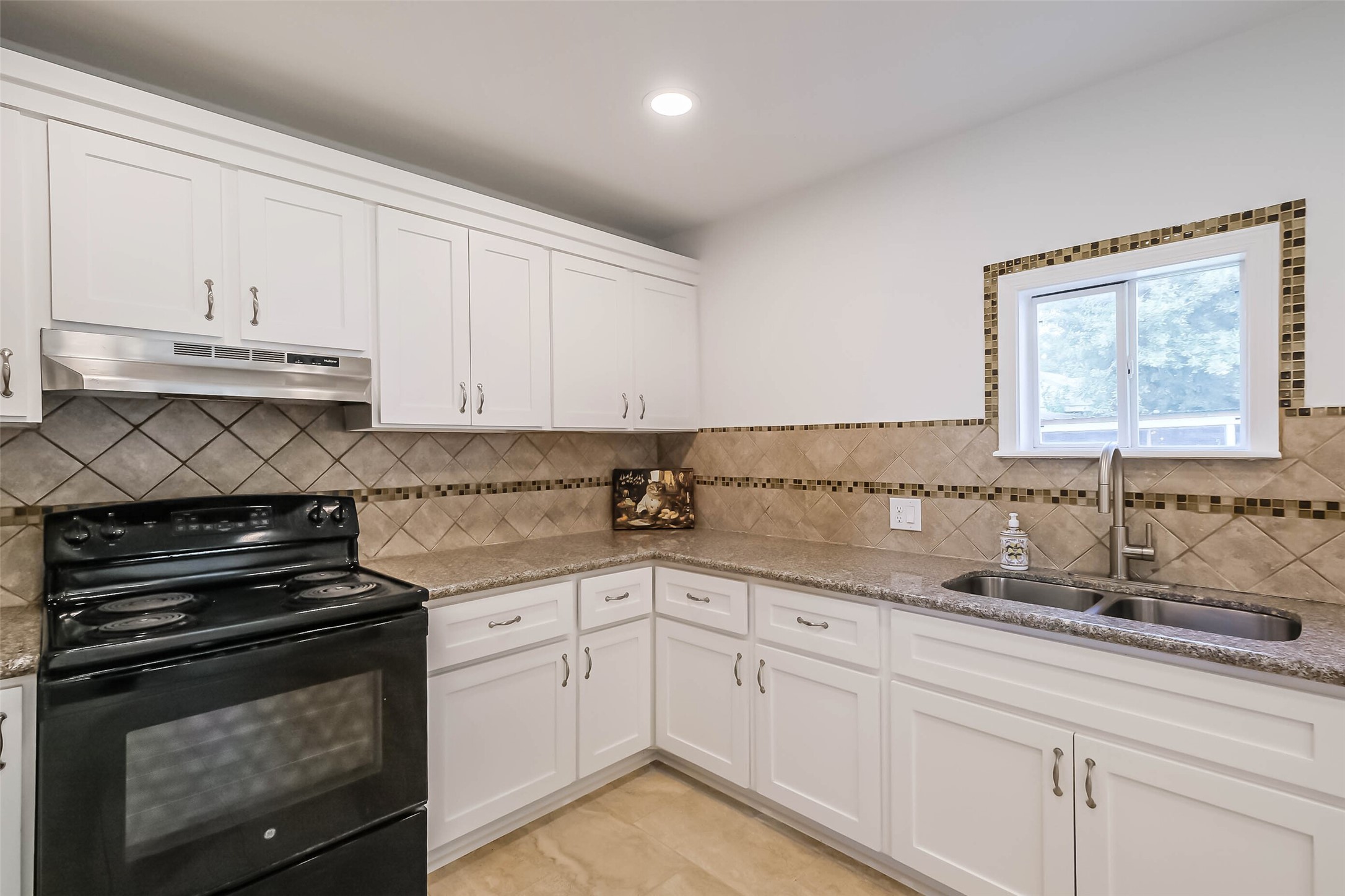 7543 Greenstone Street Houston, TX 77087 - Photo 8 of 24 a kitchen with granite countertop white cabinets and stainless steel appliances