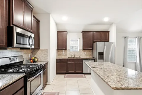 a front view of a house with garden and plants
