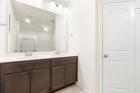 a spacious bedroom with a bed and a chandelier