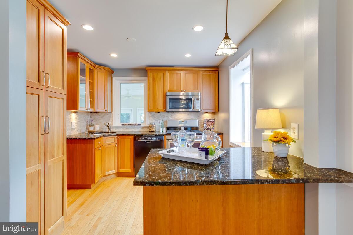 33 Dunmore Road Baltimore, MD 21228 - Photo 17 of 78 a kitchen with kitchen island granite countertop a sink cabinets and stainless steel appliances