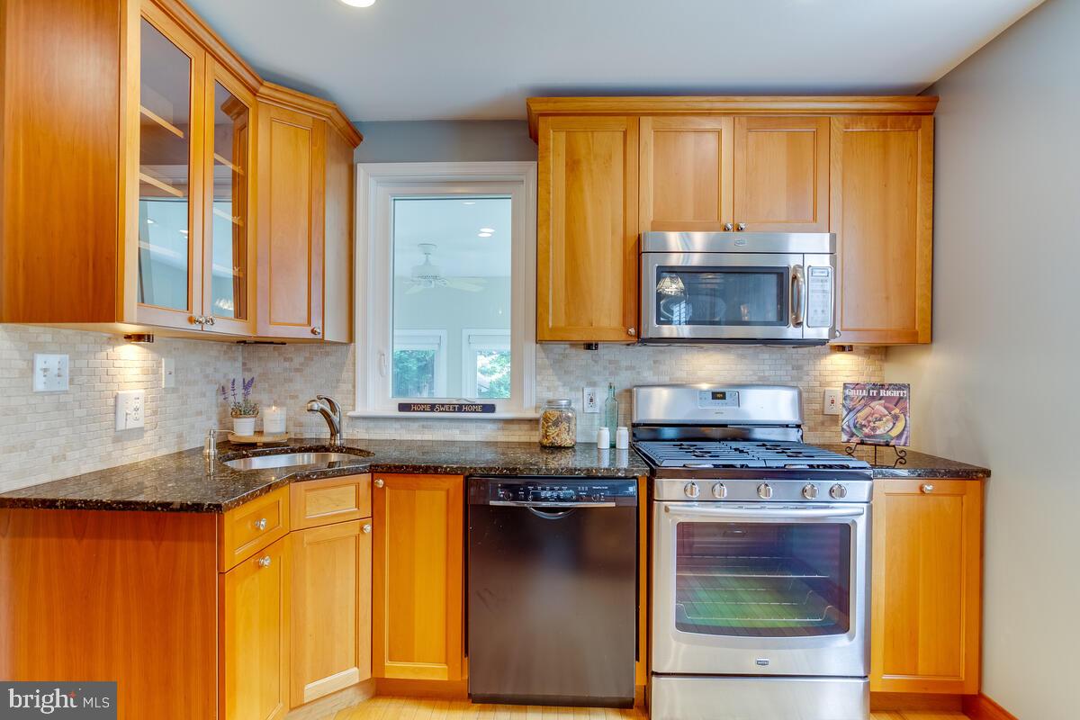 33 Dunmore Road Baltimore, MD 21228 - Photo 19 of 78 a kitchen with stainless steel appliances granite countertop wooden cabinets a stove top oven a sink and dishwasher