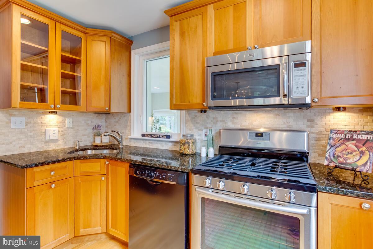 33 Dunmore Road Baltimore, MD 21228 - Photo 23 of 78 a kitchen with stainless steel appliances granite countertop a stove a sink and a microwave