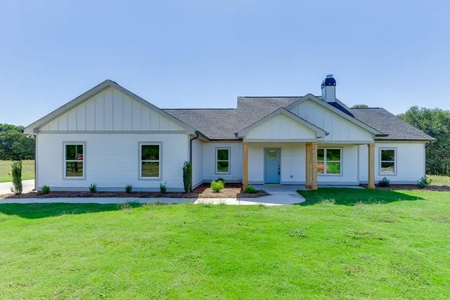 a front view of house with a garden and plants