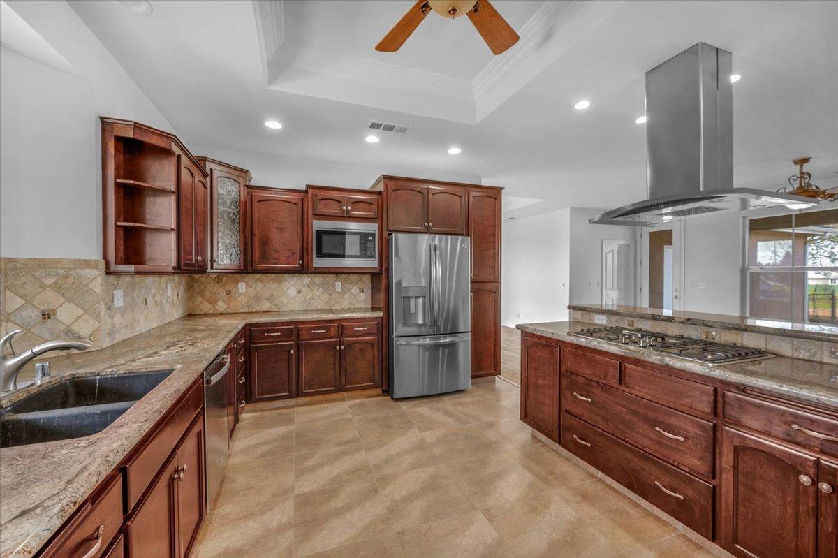 35221 John Albert Drive Madera, CA 93636 - Photo 6 of 22 a kitchen with stainless steel appliances granite countertop a sink stove and refrigerator