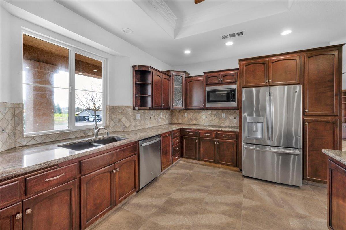 35221 John Albert Drive Madera, CA 93636 - Photo 7 of 22 a kitchen with stainless steel appliances granite countertop a refrigerator and a sink