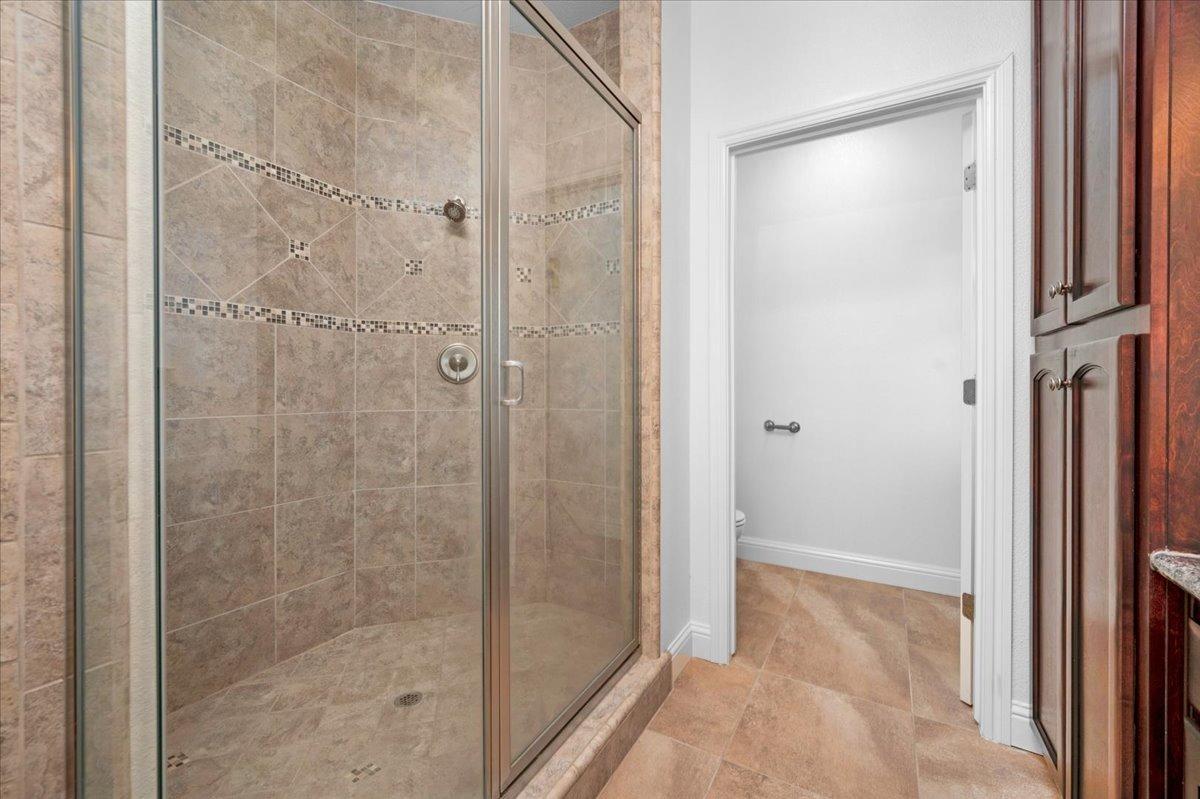 35221 John Albert Drive Madera, CA 93636 - Photo 9 of 22 a bathroom with a shower and a glass door