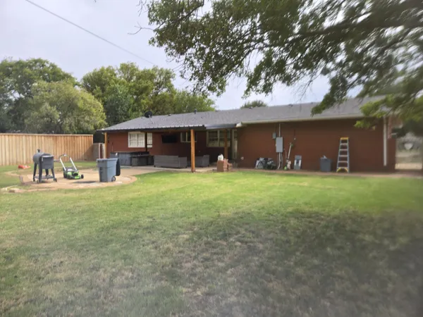 front view of a house with a yard and a large tree