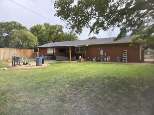 front view of a house with a yard and a large tree