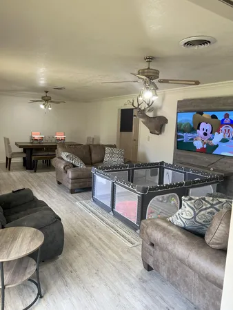 a living room with furniture chandelier and a rug
