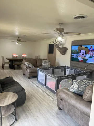 a living room with furniture chandelier and a rug