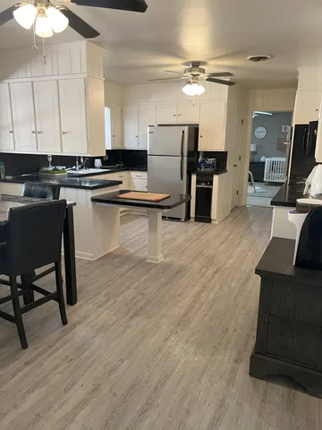 a kitchen with a table chairs refrigerator and cabinets