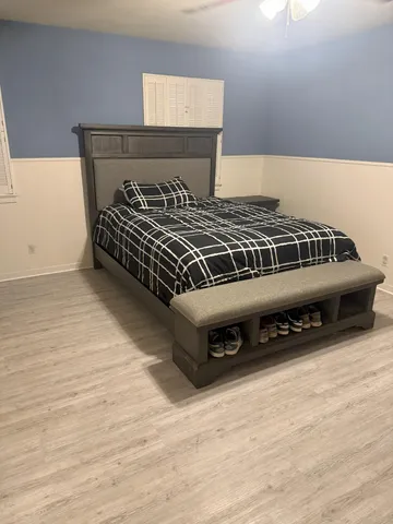 a bedroom with a bed and a wooden floor