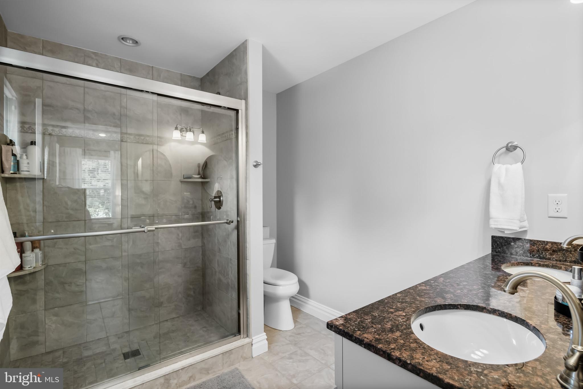 43 Estaugh Avenue Haddonfield, NJ 08033 - Photo 23 of 38 a bathroom with a granite countertop sink a toilet a mirror and shower