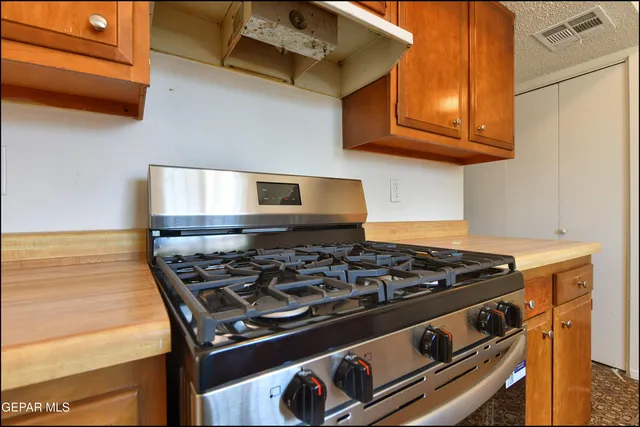 a kitchen with stainless steel appliances granite countertop a stove a sink and a microwave