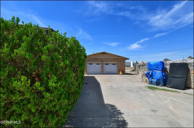 a view of a house with a yard and large trees