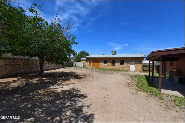 a view of a dry yard with wooden fence