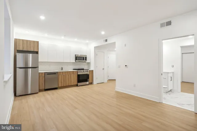 a view of a kitchen with a sink and stainless steel appliances