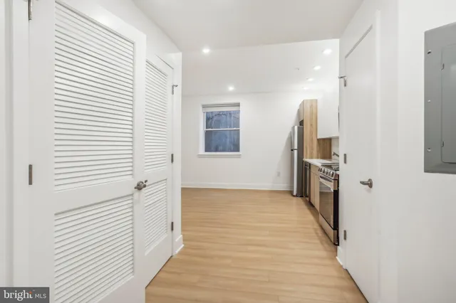 a view of a hallway with wooden floor and staircase