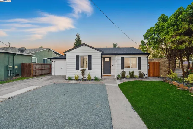 a front view of a house with a garden and yard