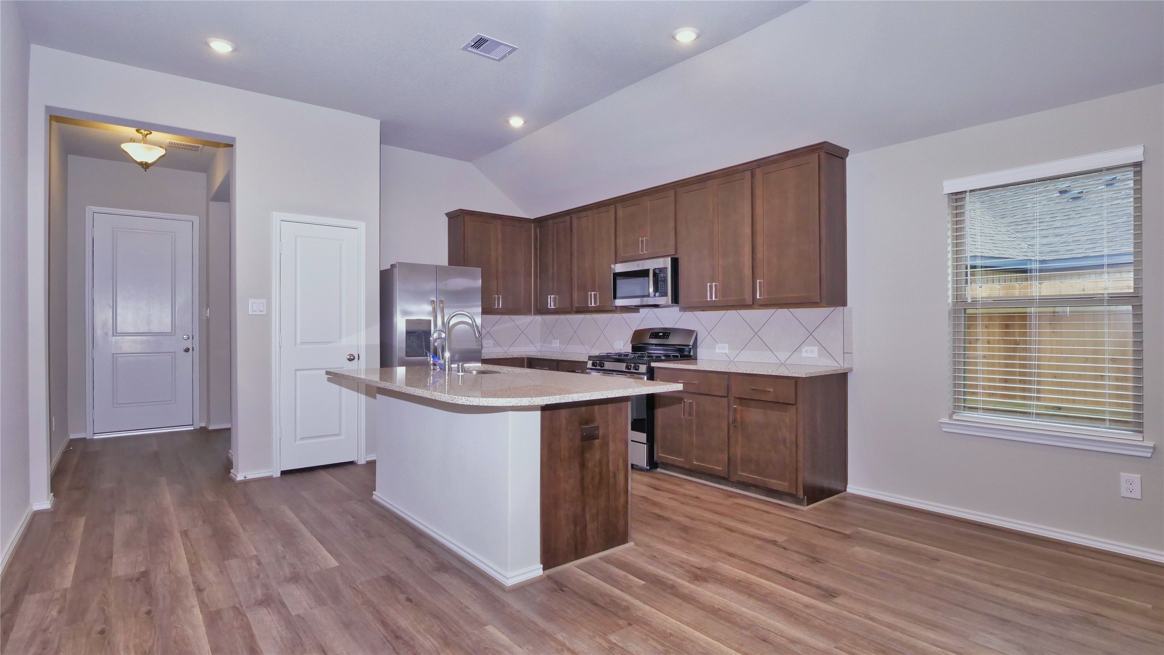 7343 Mount Greylock Loop Porter, TX 77365 - Photo 4 of 17 a kitchen with kitchen island granite countertop a sink cabinets and wooden floor