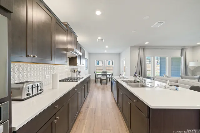 a large kitchen with stainless steel appliances lots of counter space and a sink