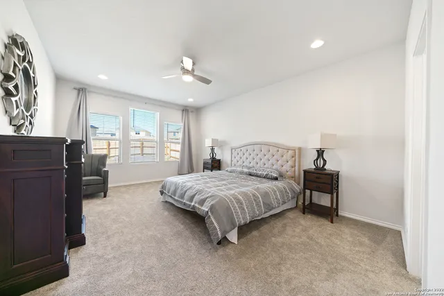 a spacious bedroom with a bed and cabinet
