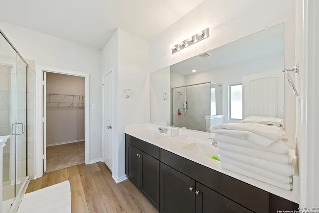a spacious bathroom with a granite countertop sink mirror and shower