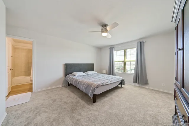 a bedroom with a large bed chandelier and a window
