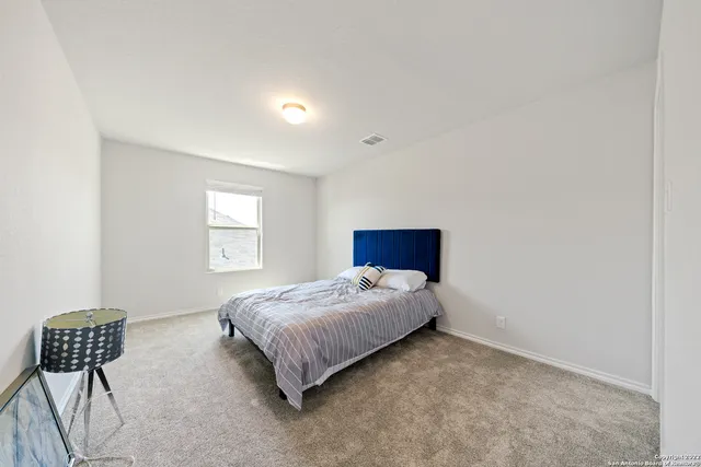 a bedroom with a bed chair and window
