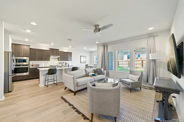 a living room with furniture kitchen view and a flat screen tv