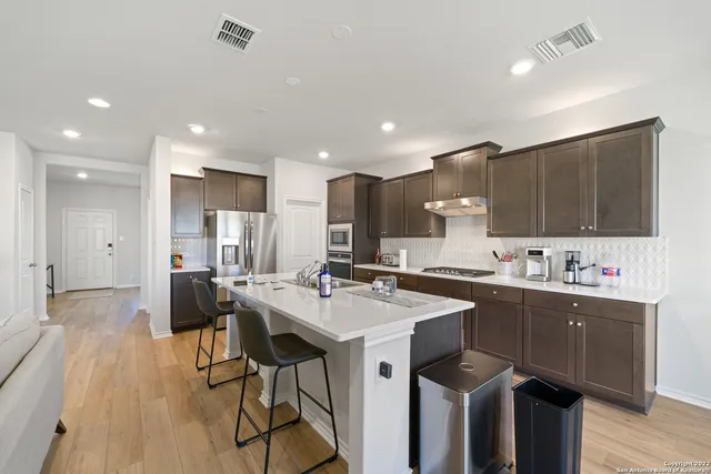 a kitchen with a sink a cabinets and wooden floor
