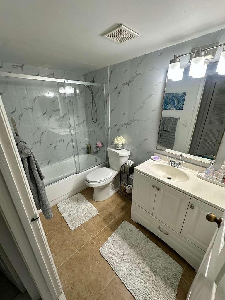 13770 Oneida Drive, Unit B2 Delray Beach, FL 33446 - Photo 11 of 14 a bathroom with a double vanity sink toilet and shower