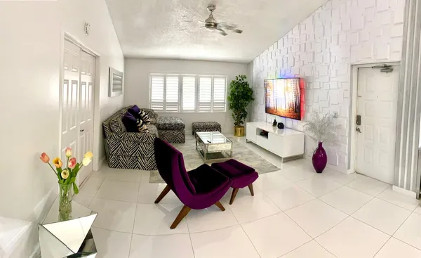 a living room with furniture a flat screen tv and a window