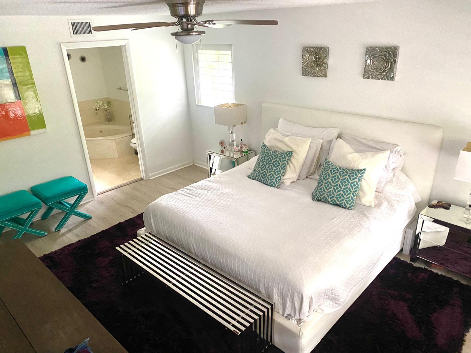 13770 Oneida Drive, Unit B2 Delray Beach, FL 33446 - Photo 8 of 14 a bedroom with a bed and a chandelier