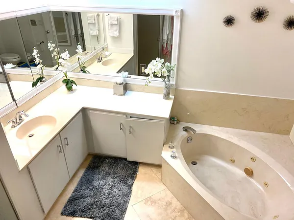 a bathroom with a bathtub sink and mirror