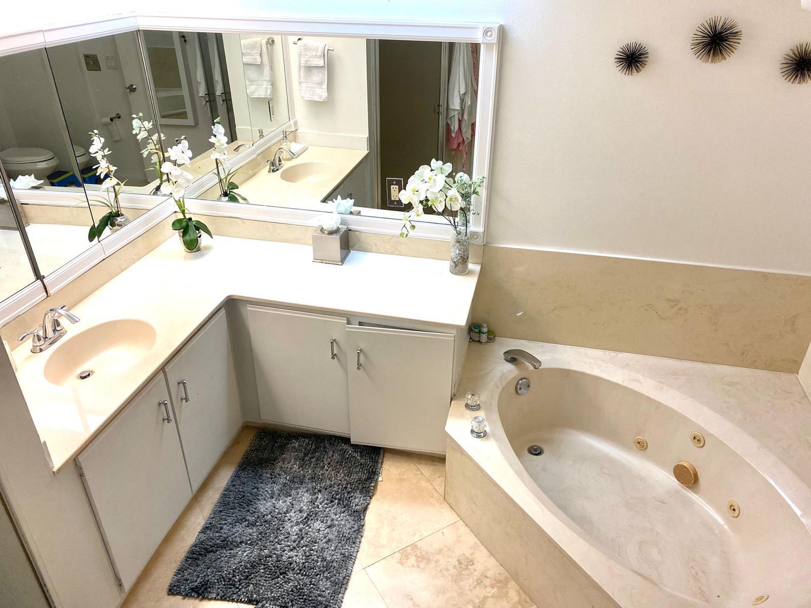 13770 Oneida Drive, Unit B2 Delray Beach, FL 33446 - Photo 9 of 14 a bathroom with a bathtub sink and mirror