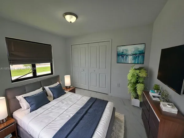 a bedroom with a bed and a flat screen tv