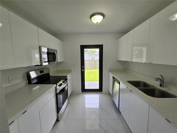 a kitchen with a sink a stove and cabinets
