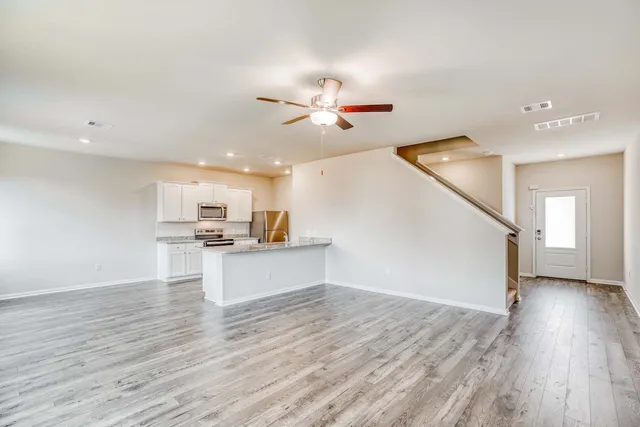 a view of a kitchen with wooden floor and a sink