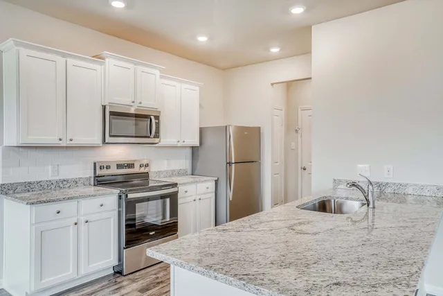 a kitchen with stainless steel appliances granite countertop a refrigerator sink and cabinets