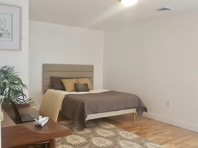a bedroom with a bed and a potted plant