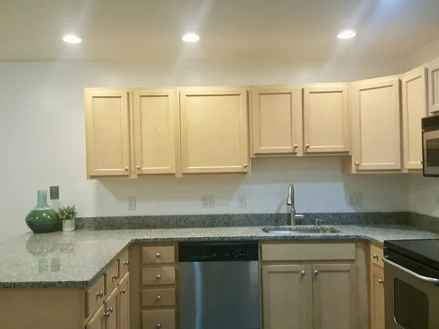 a kitchen with stainless steel appliances granite countertop a sink and cabinets