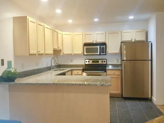 a kitchen with stainless steel appliances granite countertop a refrigerator a stove a sink and a granite counter tops