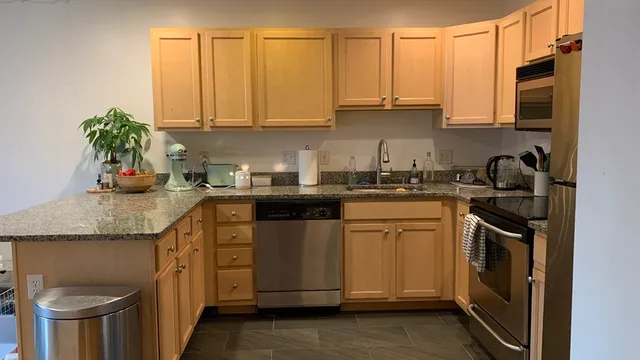 a kitchen with stainless steel appliances granite countertop a sink a stove and cabinets
