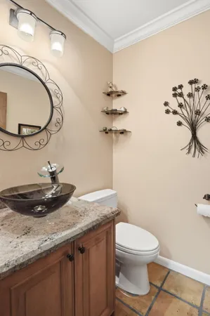 a bathroom with a granite countertop sink a toilet and a mirror