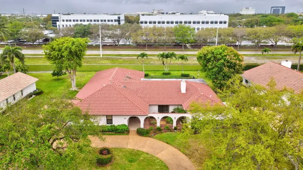 an aerial view of a house with a garden and lake view